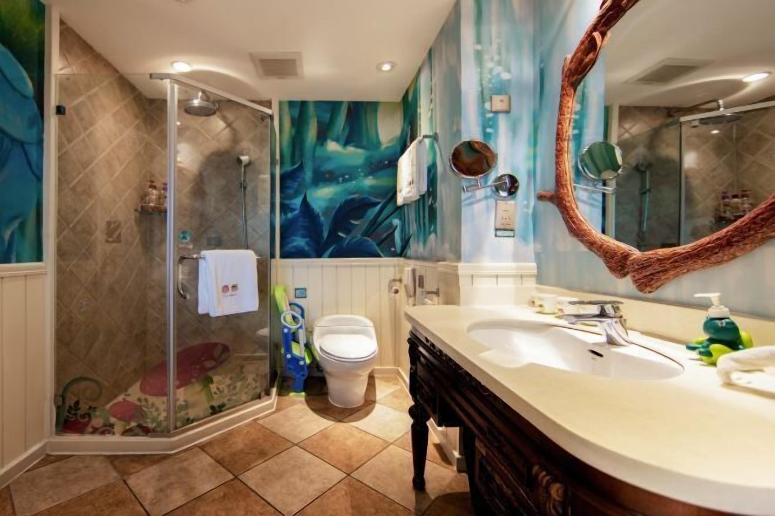 Ein Badezimmer mit einer Duschkabine, einem großen Spiegel und einem Waschtisch mit Spüle und Arbeitsfläche.