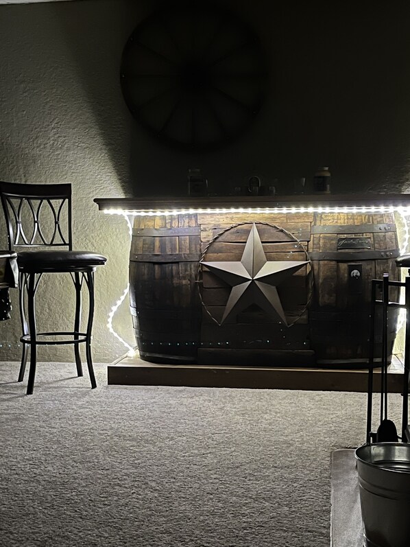 Una habitación con una barra de madera rústica, un adorno con forma de estrella y una silla.