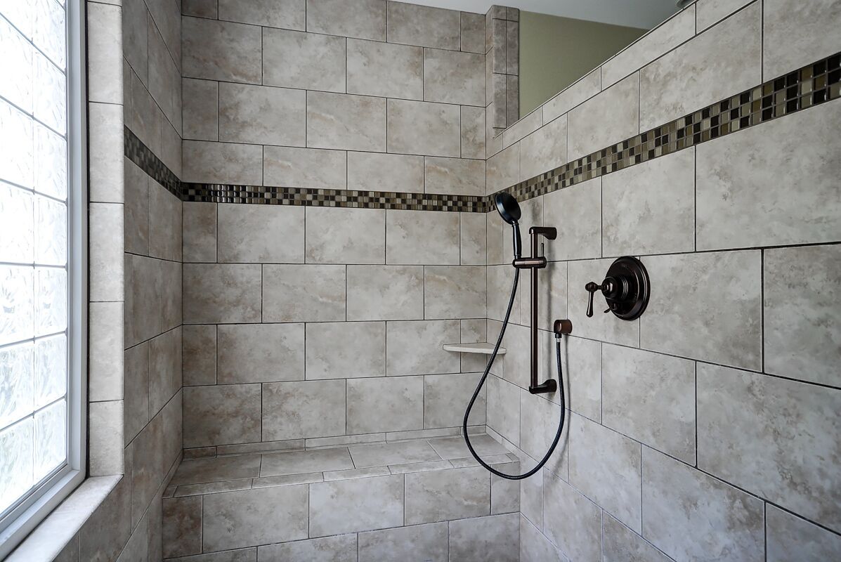 A shower area with tiled walls and a window.