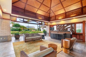Een ruime lobby met een hoge plafond, een receptiebalie, comfortabele zitplaatsen en uitzicht op de omgeving.