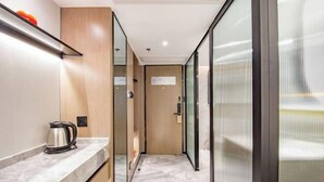 A corridor with a marble countertop, a kettle, and a door leading to another room. - Longquan Hotel (Nandaqiao Flagship) (Haikou)