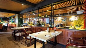 A restaurant with wooden panel ceiling, a counter with various items, and several dining tables with chairs. - Longquan Hotel (Nandaqiao Flagship) (Haikou)