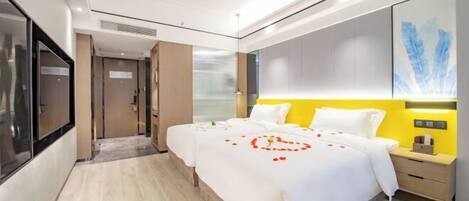 A modern hotel room with a large bed, a bedside table, a TV, and a large window.