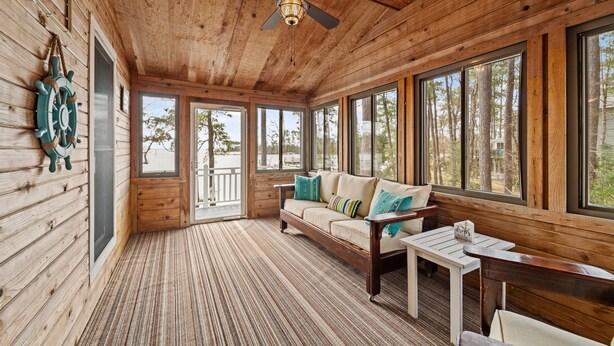 A wooden cabin interior with a sofa, a table, and a ceiling fan. - Port Peninsula Waterfront Paradise - Waterfront with Dock & Boat Lift (Oriental)
