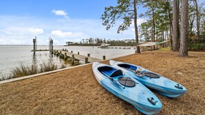 Two kayaks on a grassy area near a dock and water. - Port Peninsula Waterfront Paradise - Waterfront with Dock & Boat Lift (Oriental)
