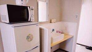 A compact kitchenette with a microwave, refrigerator, and a small sink. - Mr.KINJO Happiness Resort 1 (Miyakojima)