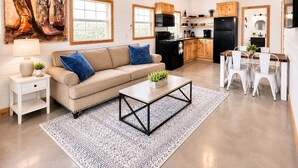 Ein modernes Wohnzimmer mit Sofa, Couchtisch und Essbereich.