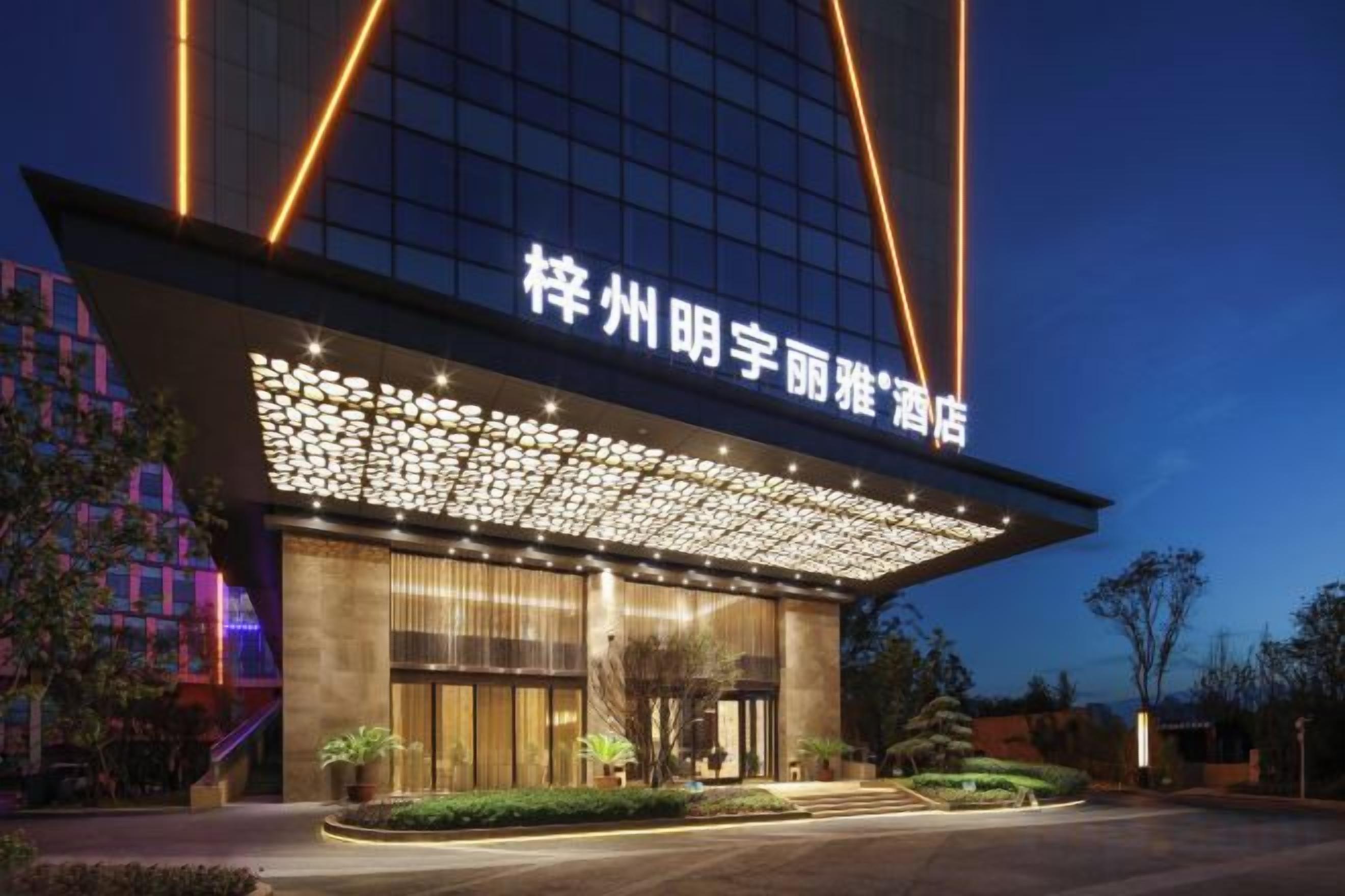 A hotel with a modern facade, illuminated signage, and a well-maintained entrance area.