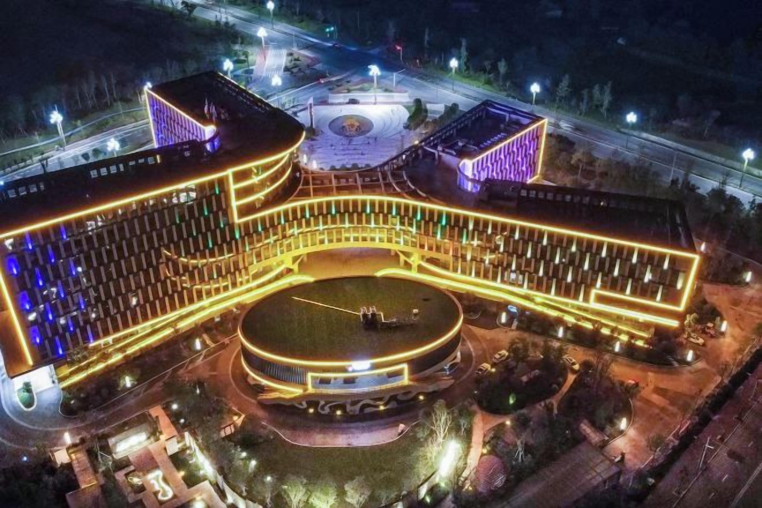 A large hotel with a central courtyard, multiple wings, and a circular fountain.