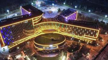 A large hotel with a central courtyard, multiple wings, and a circular fountain.