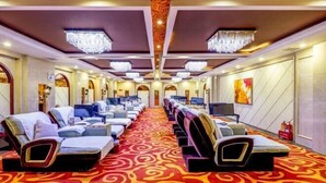 Una habitación de hotel con alfombra roja, varias camas y un candelabro.