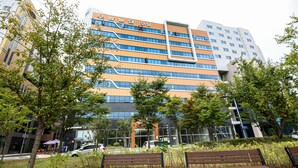 Un edificio moderno con fachada de vidrio y un letrero en un idioma extranjero.