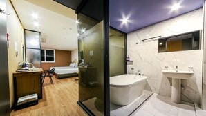 Una habitación de hotel moderna con un escritorio de madera, una cama y un separador de vidrio.