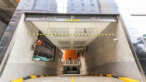 Entrada a un estacionamiento subterráneo con señales direccionales que indican 'SALIDA' y 'ENTRADA'.