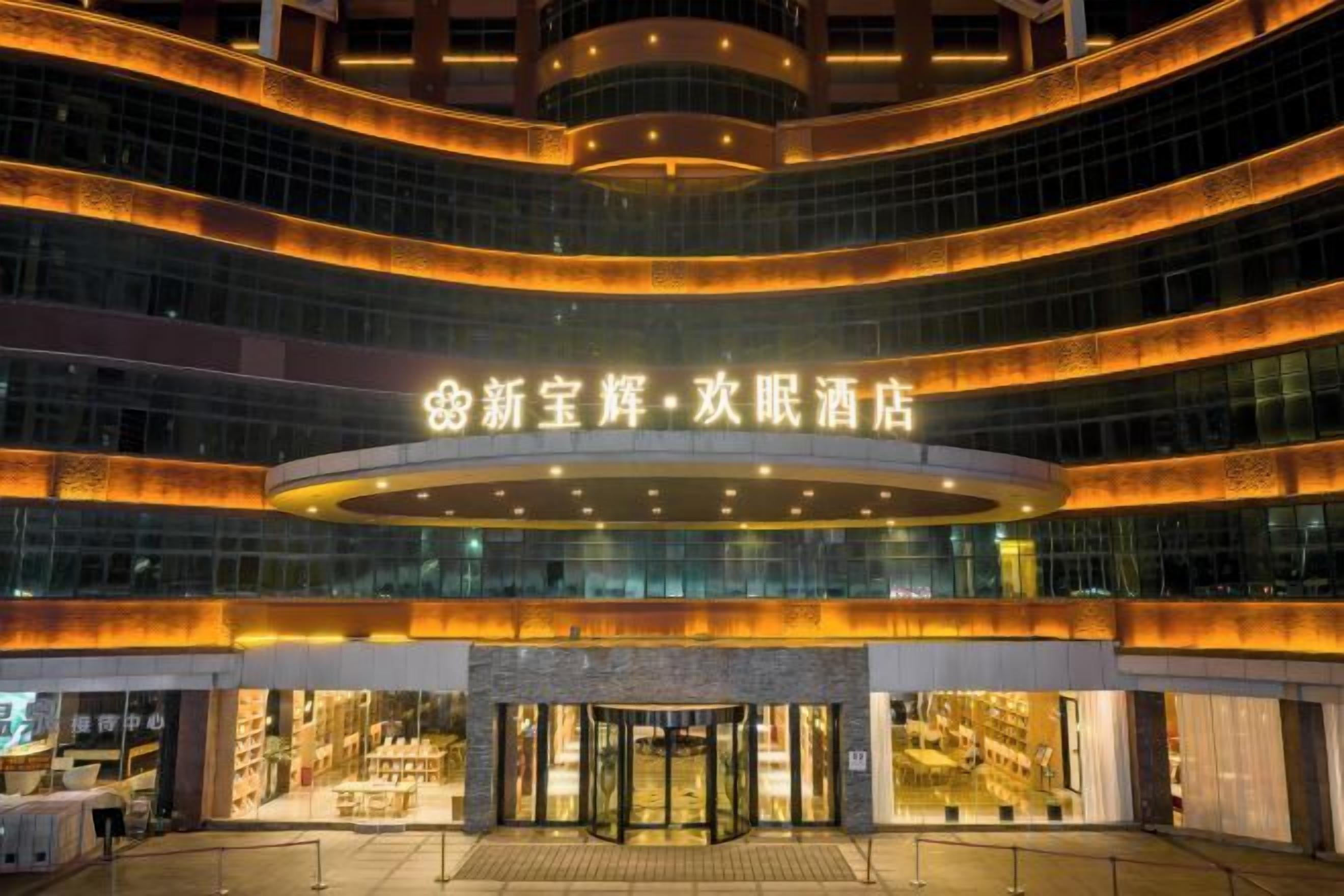 A multi-story hotel with a prominent entrance and a circular glass facade.