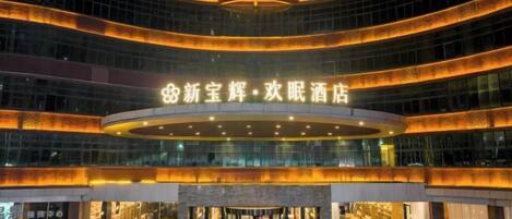 A multi-story hotel with a prominent entrance and a circular glass facade.