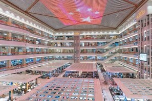 A multi-level atrium with a central open space, multiple floors, and a modern design. - NEW BAO HUI · HAPPY SLEEP HOTEL (Ganzhou)