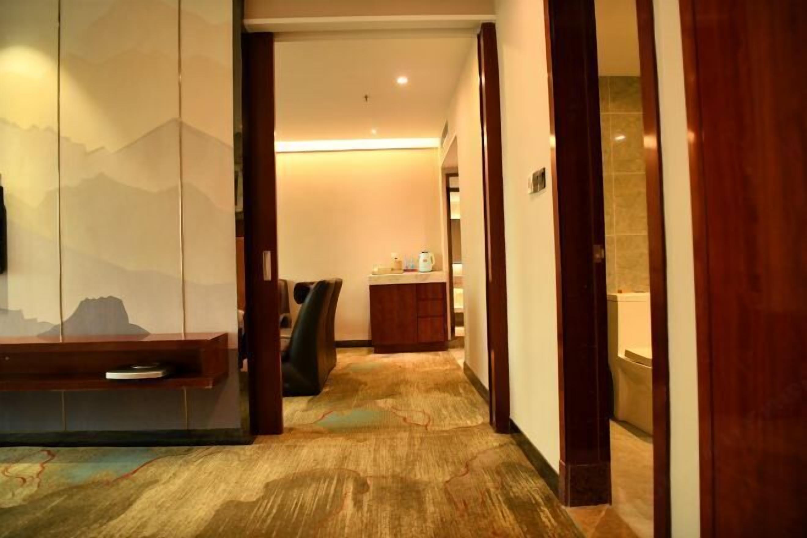 A hallway with a wooden bench, a desk, and a small cabinet.