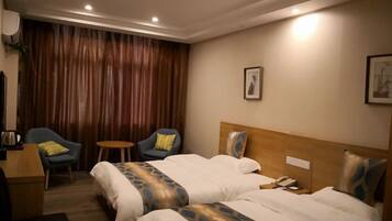 A hotel room with two beds, a desk, and a chair.