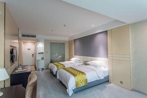 A hotel room with two beds, a desk, a chair, a TV, and a minibar. - Sunjiang Hotel (Quanzhou)