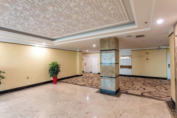 A spacious lobby with a marble floor, a decorative ceiling, and a potted plant. - Sunjiang Hotel (Quanzhou)
