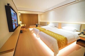 A hotel room with a large bed, a desk, a chair, a TV, and a lamp. - Sunjiang Hotel (Quanzhou)