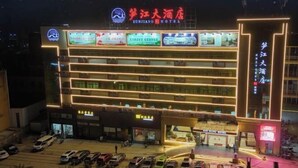 A hotel with multiple floors, a prominent sign, and a parking lot with several cars. - Sunjiang Hotel (Quanzhou)