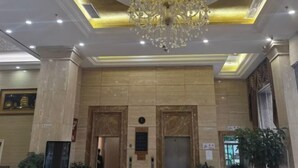 A lobby with a grand chandelier, marble walls, and an elevator. - Sunjiang Hotel (Quanzhou)