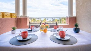 A dining table set for two with a view of the sky and trees. - Le Village (E1212) by Interhome (Agay Village Cap Esterel)