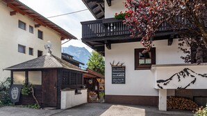 Un edificio tradicional con balcón y vista a la montaña, con un letrero que indica ser un negocio familiar.