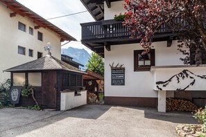 A traditional building with a balcony, a mountain view, and a sign indicating a family-owned establishment.