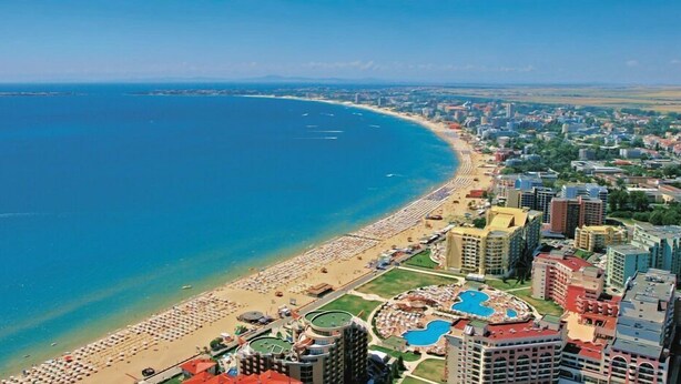 A coastal cityscape with a beachfront hotel featuring multiple swimming pools, a beach, and surrounding high-rise buildings. - Studio - Sleeps 4 & Access to Pools (Bourgas)