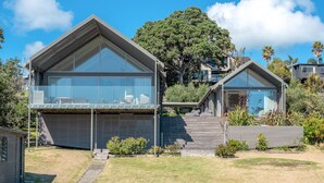 Una casa moderna con ampie vetrate, tetto piano e giardino curato.