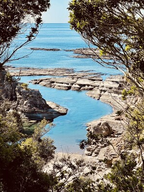 Eine Küstenlandschaft mit Felsformationen und klarem, blauem Wasser.