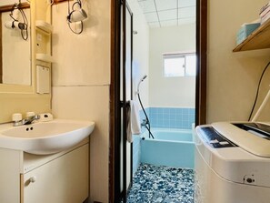 Ein Badezimmer mit Waschbecken, Spiegel und Duschbereich.