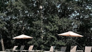 Ein klares Schwimmbecken mit Liegestühlen und Sonnenschirmen.