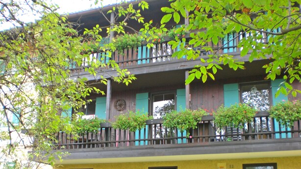 Un edificio a più piani con balconi, una torre dell'orologio e piccole finestre.