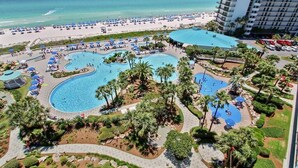 Un resort con varias piscinas, playa y vista al océano.