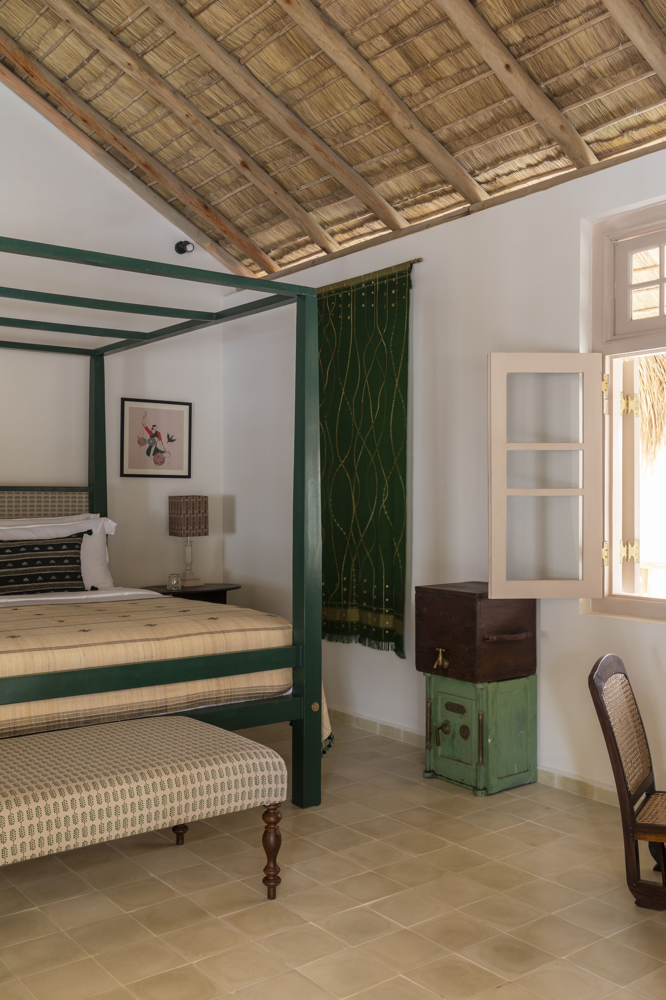 A room with a bed, a chair, a cabinet, and a window.