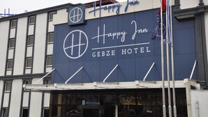 The exterior of the Happy Inn Gebze Hotel with a prominent sign and flag. - Happy Inn Gebze Hotel (Gebze)