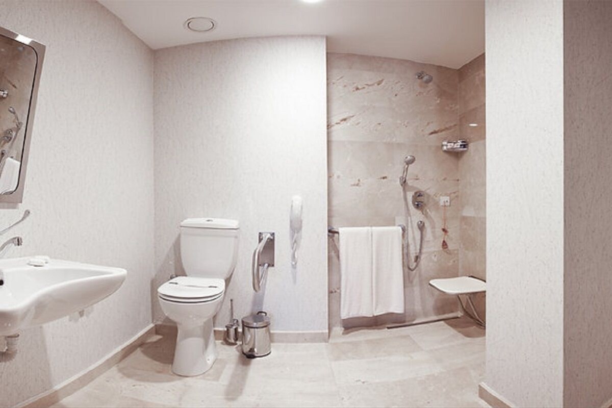 Une salle de bain équipée de toilettes, d’un lavabo, d’une douche et d’un porte-serviettes.