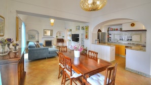 A spacious living area with a dining table, sofas, and a kitchen area with a tiled backsplash. - Villa Micol: A welcoming two-story independent house located in a picturesque neighborhood of Positano, with Free WI-FI. (Positano)