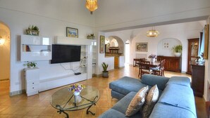 A living room with a TV, sofa, and glass coffee table. - Villa Micol: A welcoming two-story independent house located in a picturesque neighborhood of Positano, with Free WI-FI. (Positano)