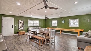 A dining area with a wooden table and benches, green walls, and ceiling fans. - Welcoming Tow Home ~ 1 Mi to Lake Buchanan! (Tow)