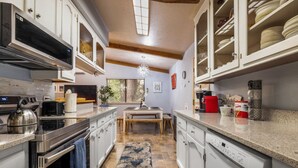 Una cocina moderna con armarios blancos, electrodomésticos de acero inoxidable y una isla central.