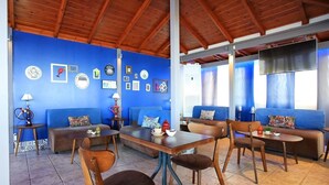 A cozy room with blue walls, wooden furniture, and various decorative items. - Beachfront Apartments in Gouves (Hersonissos)