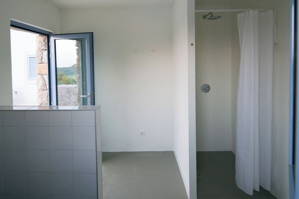 Une salle de bain avec une douche, des toilettes et un lavabo.