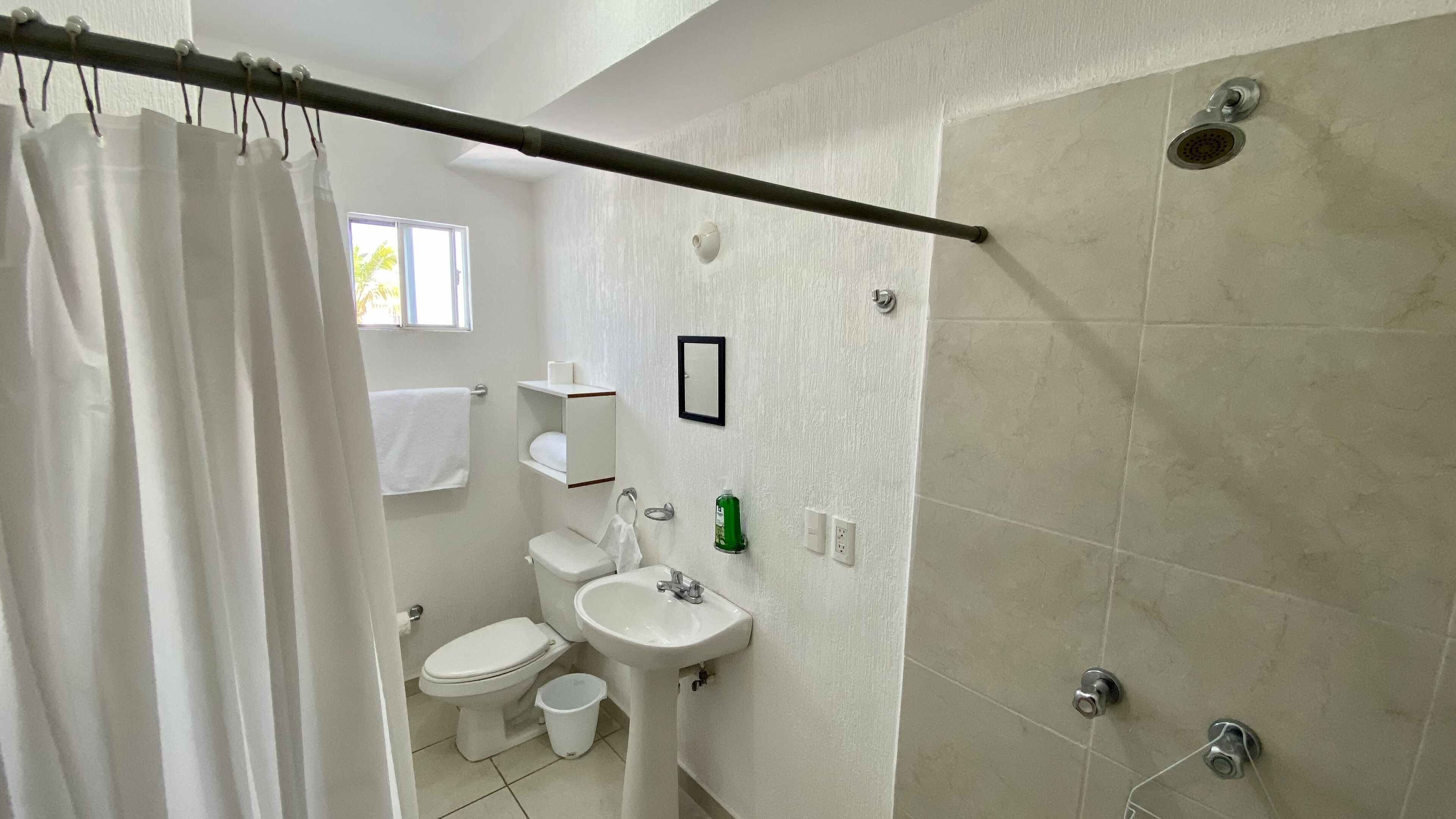 Une salle de bain avec des toilettes, un lavabo et une douche.
