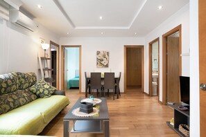 Un salon comprenant un canapé, une table basse et un coin repas avec des chaises et une table.