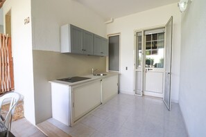 A compact kitchen with a sink, cabinets, and a window.